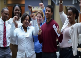 A group of excited, professionally-dressed young adults.